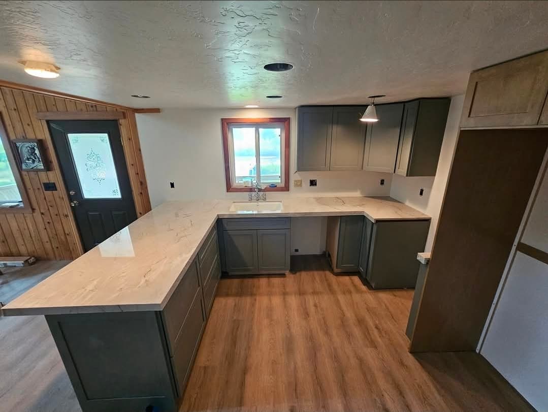 Green cabinets with white stone countertops